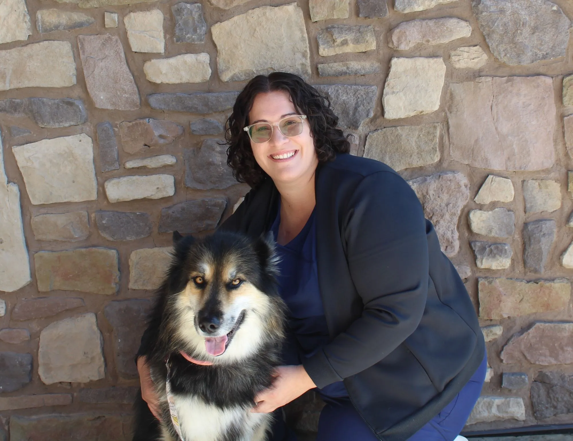 Portrait of Anna, Certified Veterinary Technician at Farr West Animal Hospital, with a dog