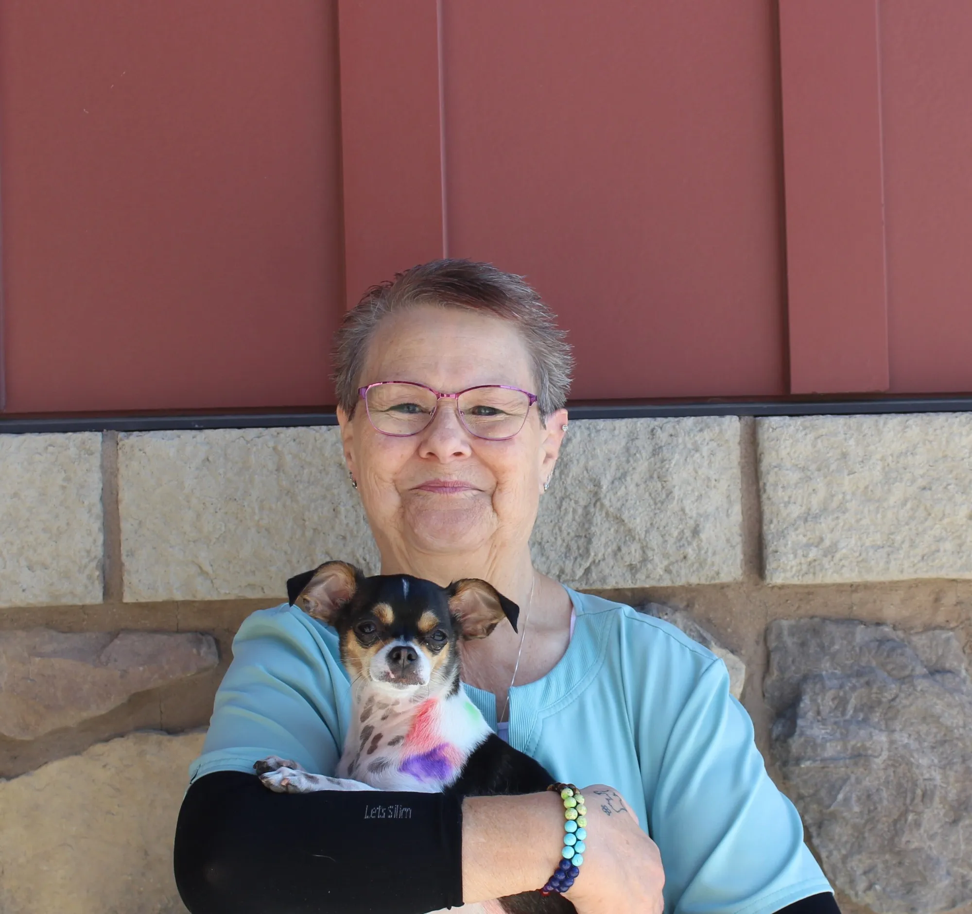 Portrait of Heidi, Receptionist at Farr West Animal Hospital, holding a Chihuahua