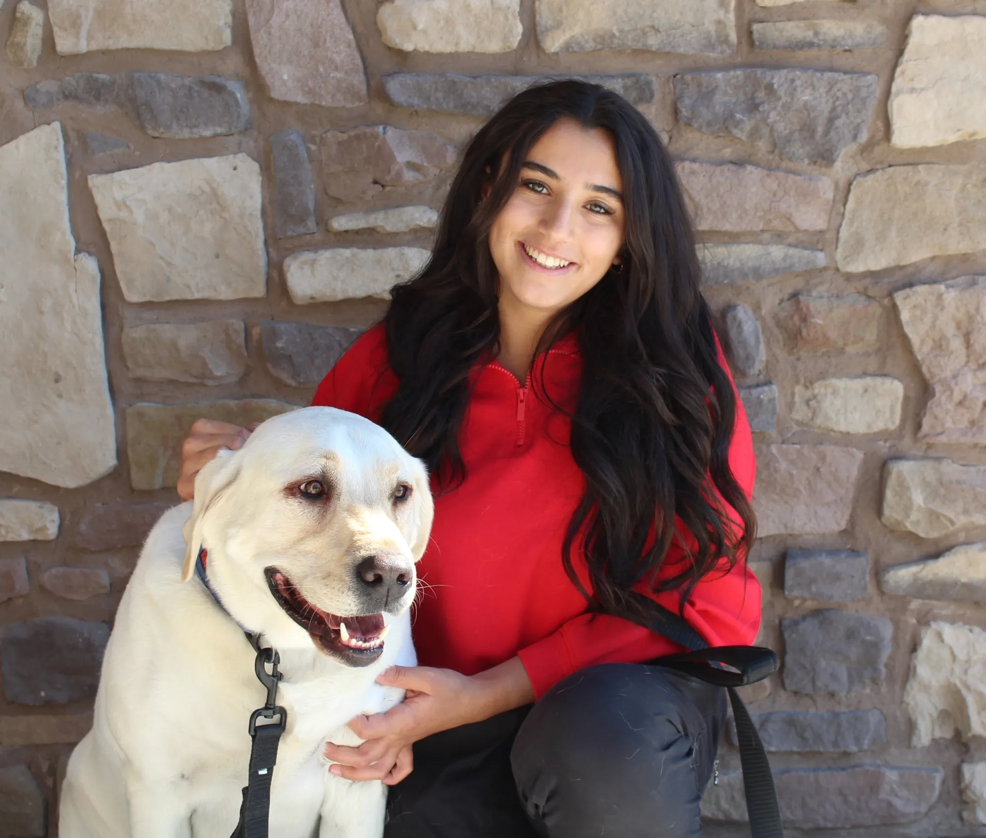 Portrait of Kenadee, Veterinary Technician at Farr West Animal Hospital, with a yellow Labrador